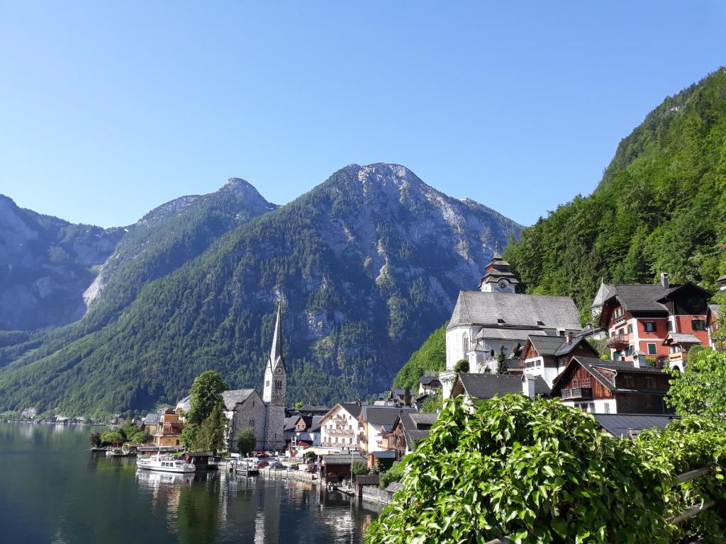 a town on the water with mountains in the background at Alpen Apartement in Hallstatt