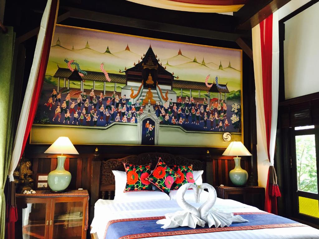 A richly decorated bedroom features a canopied bed beneath a large traditional mural.