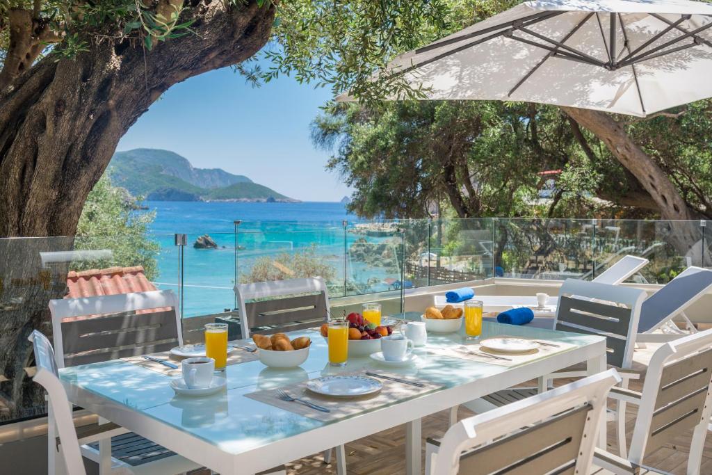 - une table avec de la nourriture et une vue sur l'océan dans l'établissement Odysseus Villa, à Paleokastritsa