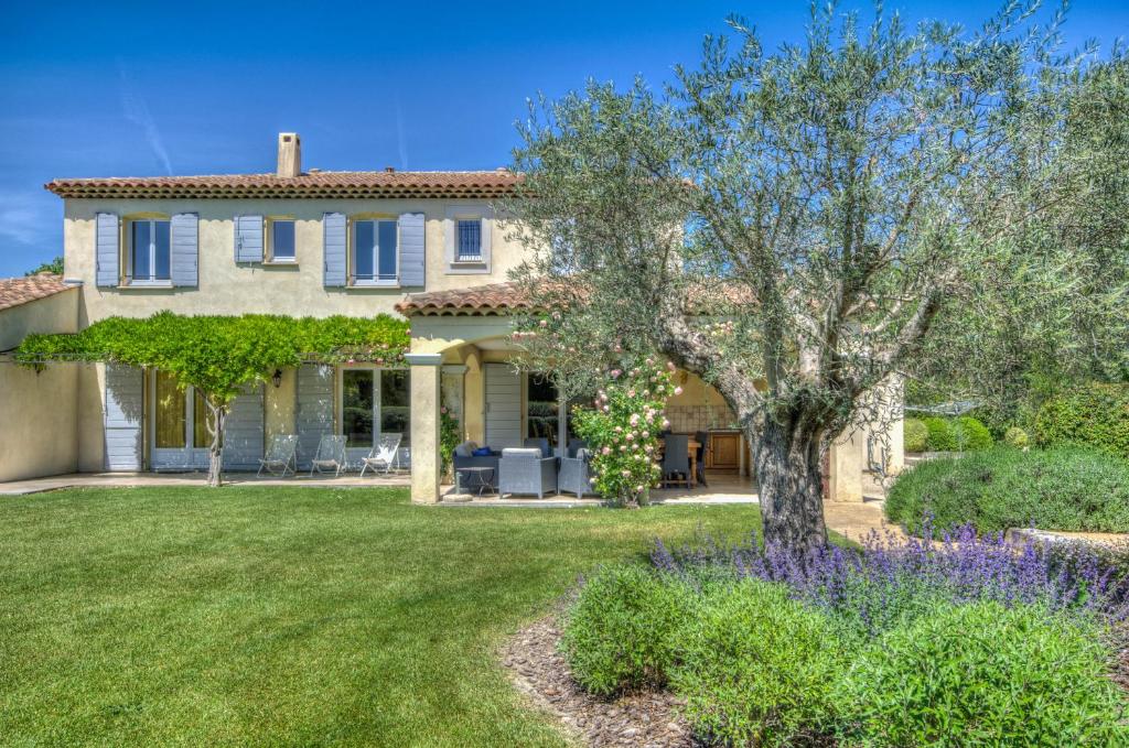 una casa con un árbol en el patio en Villa Indigo, en Saint-Rémy-de-Provence