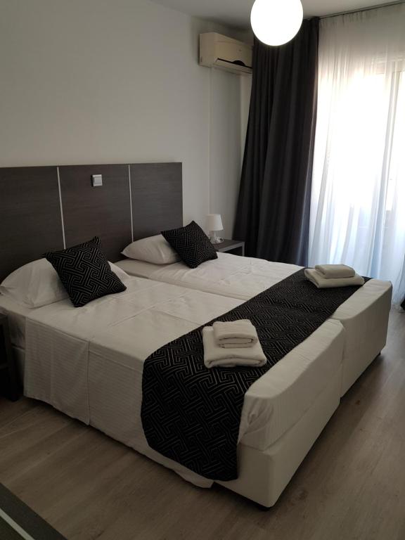 een slaapkamer met 2 bedden en handdoeken bij Les Palmiers Petrou Apartments in Larnaka