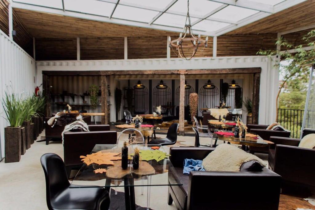 un restaurante con sofás, mesas y sillas en Pousada Cafe Poesia, en Campos do Jordão