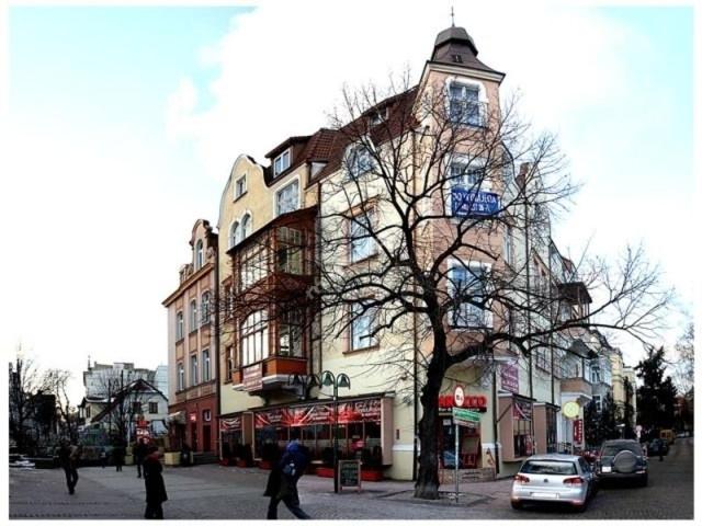 a building on a street with people walking in front of it at Małgorzata Pokoje in Sopot