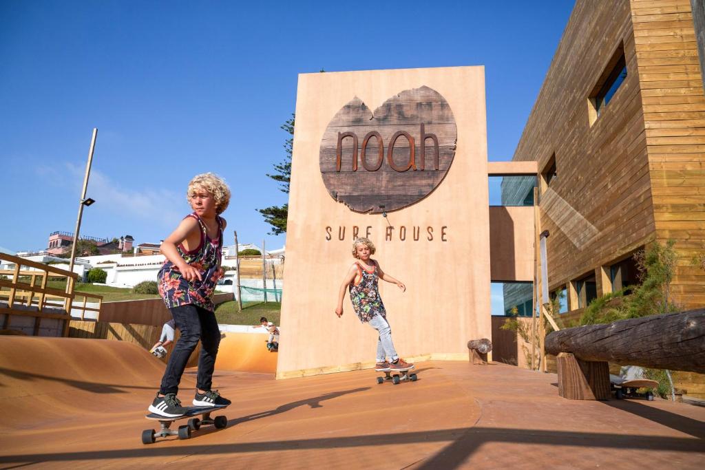 two young boys riding skateboards in a skate park at Noah Surf House Portugal in Santa Cruz