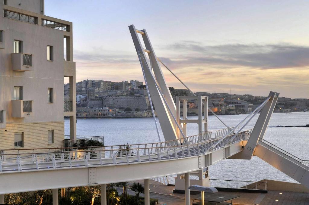 a bridge over the water next to a building at Modern 2BR Sliema Apartment in Sliema