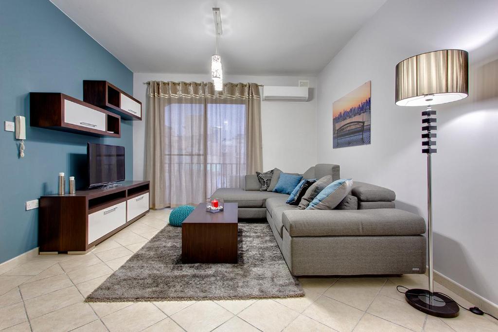een woonkamer met een bank en een tv bij Modern 2BR Sliema Apartment in Sliema
