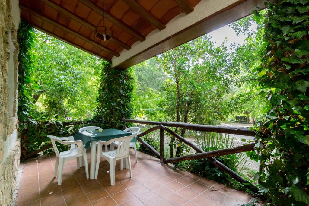 patio con mesa y sillas en el balcón en Casas Rurales Los Enebros Nerpio, en Nerpio