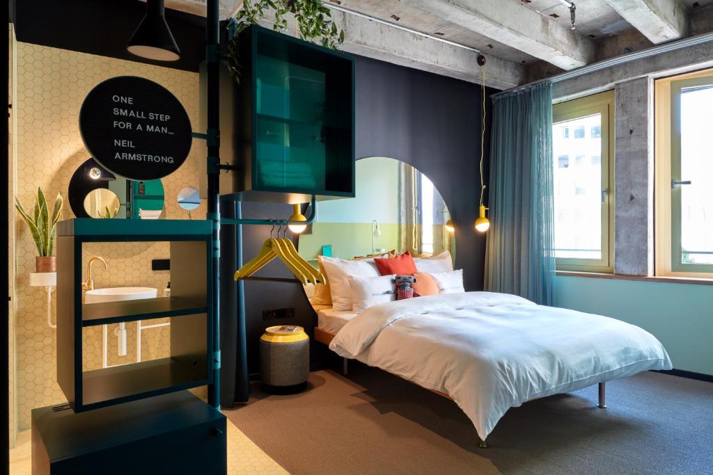 a bedroom with a bed and a tv on the wall at 25hours Hotel The Circle in Cologne