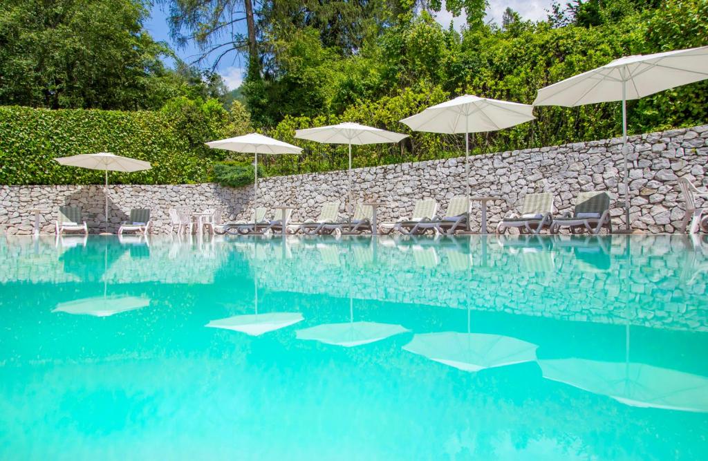 a swimming pool with chairs and umbrellas at Villa Margherita in Tenna 