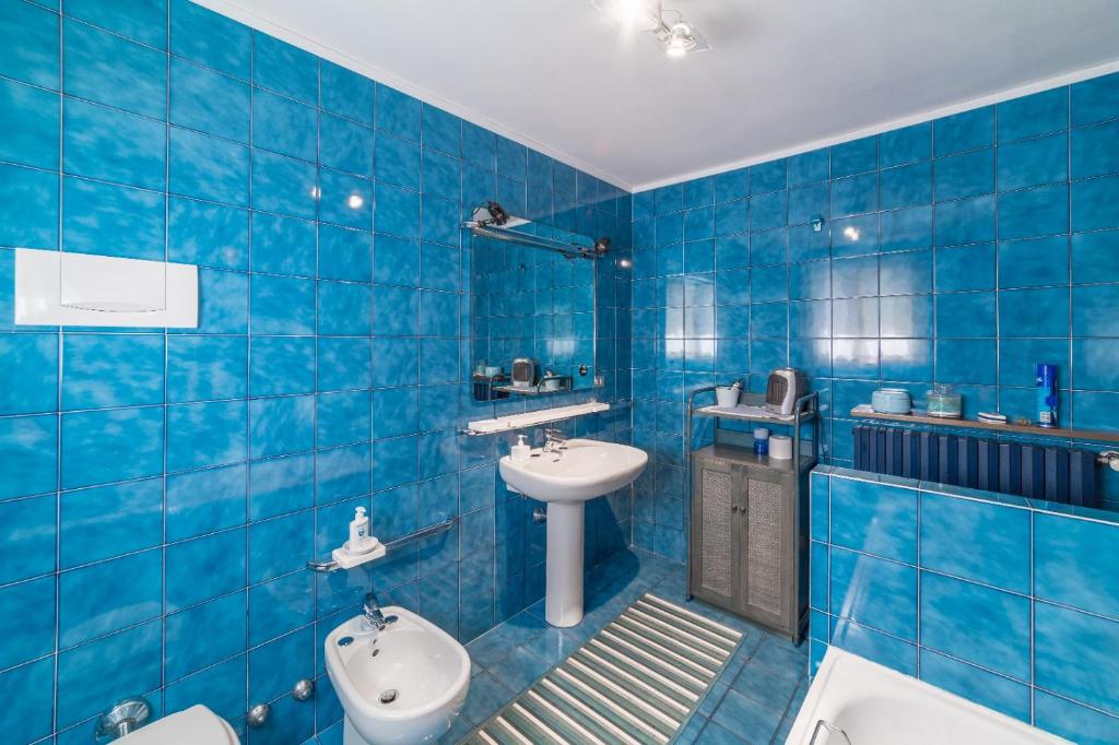 bagno piastrellato blu con lavandino e servizi igienici di Bed and Breakfast Miotto a Montegalda
