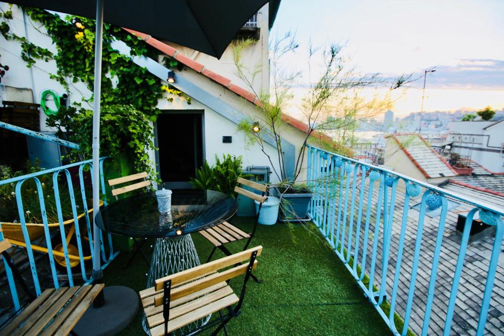 - un balcon avec une table, des chaises et un parasol dans l'établissement G.A.P. genova aquarium pentahouse, à Gênes