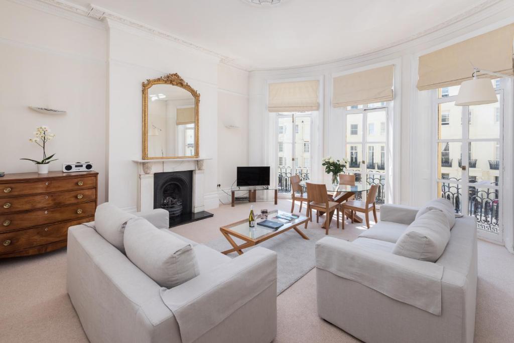 a living room with white furniture and a fireplace at Brighton Brunswick Apartments in Brighton & Hove
