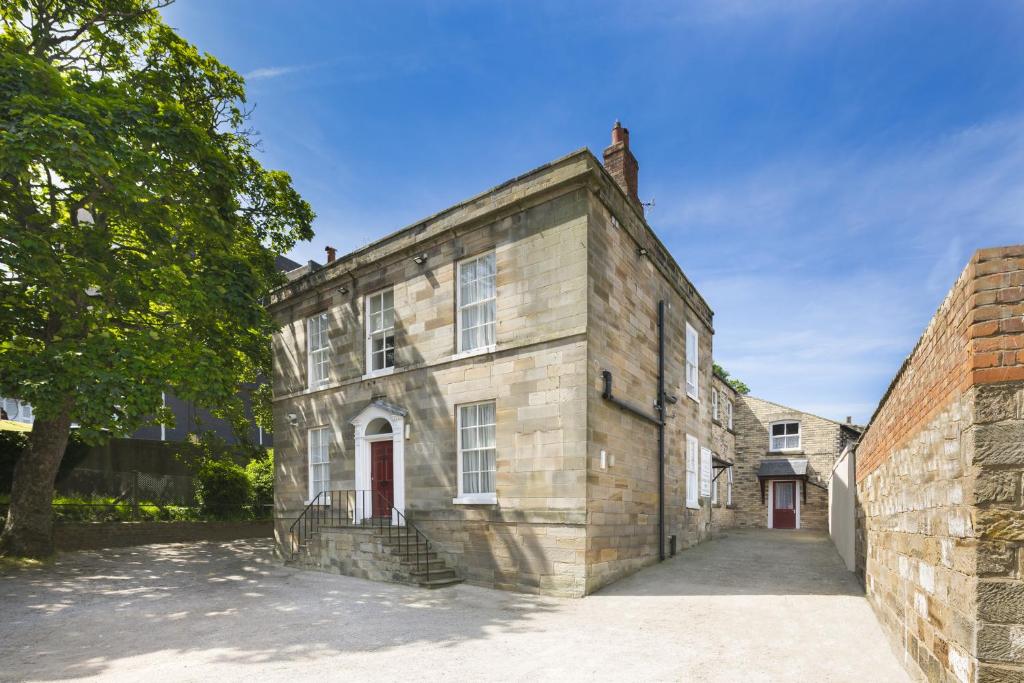 an old stone building with a red door at Lobster Hall - Room Only in Whitby