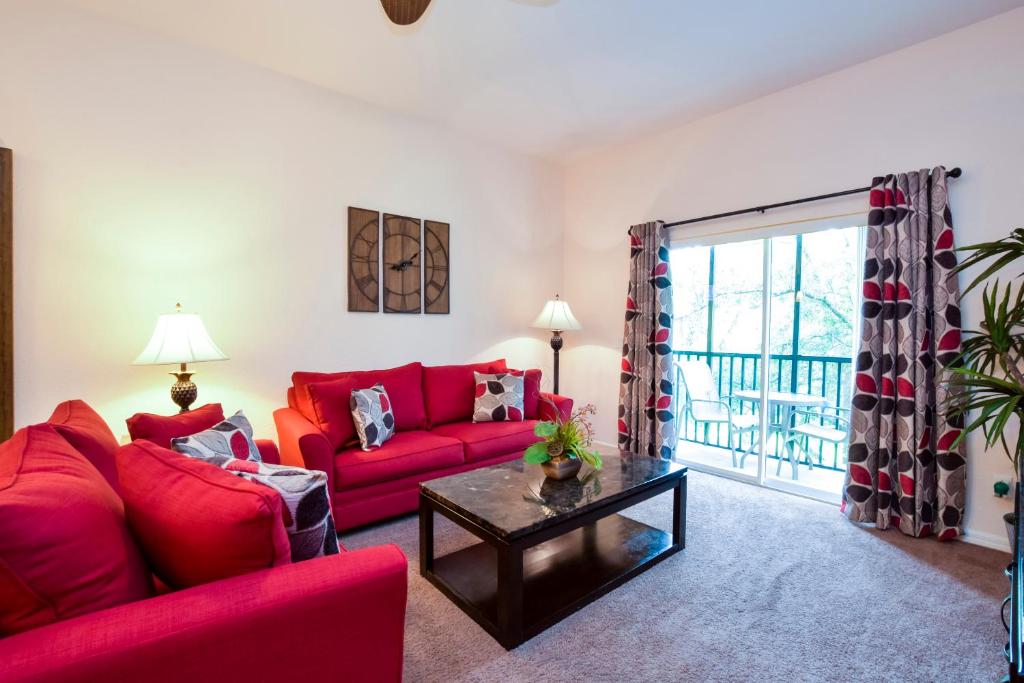 een woonkamer met rode banken en een tafel bij Bahama Bay in Kissimmee