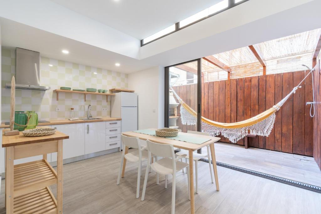 eine Küche mit einem Tisch und Stühlen sowie einen Balkon in der Unterkunft Slowlife Furadouro in Furadouro