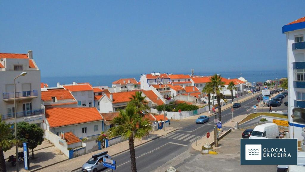 a town with orange roofs and a street with cars at Casa Ouriceira, Centro Ericeira in Ericeira