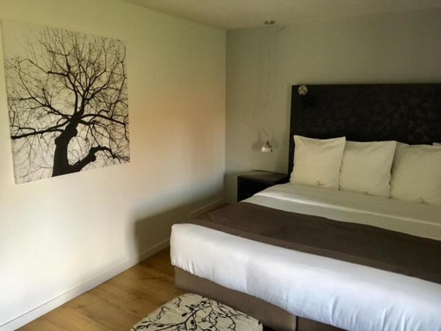 Un dormitorio con una cama y un cuadro en la pared. en Casa9 Hôtel, en Thuir
