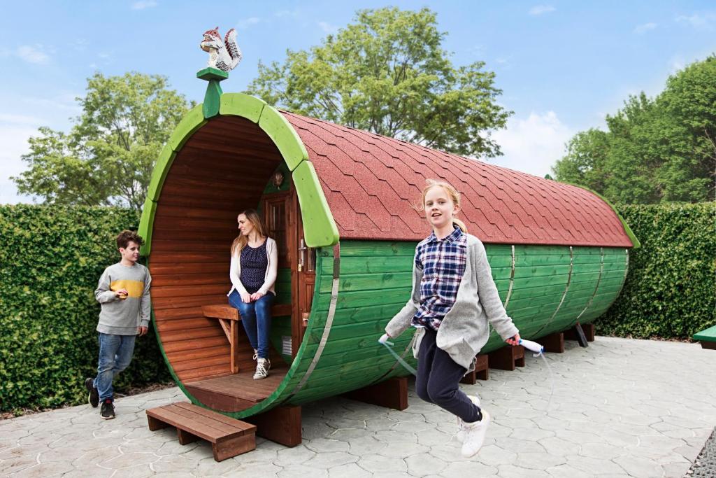 a group of people standing outside of a play house at LEGOLAND Wilderness Barrels & Cabins in Billund