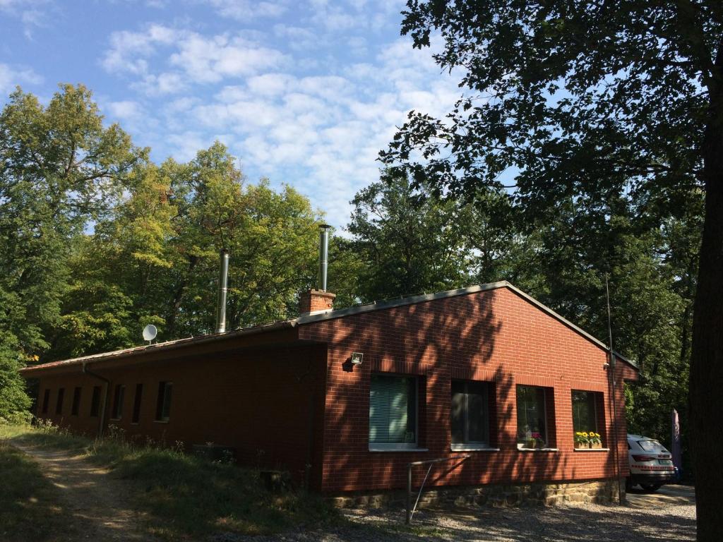 a small red building with trees in the background at Apartmán Brno Jelenice in Brno