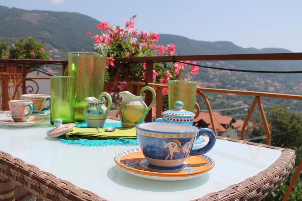 - une table avec des tasses et des assiettes sur le balcon dans l'établissement Dafne Holiday, à Agerola
