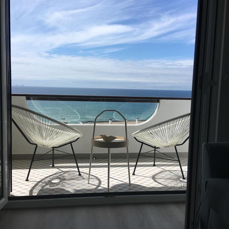 two chairs and a table on a balcony with the ocean at Salty House - Casa Salgada in Foz do Arelho