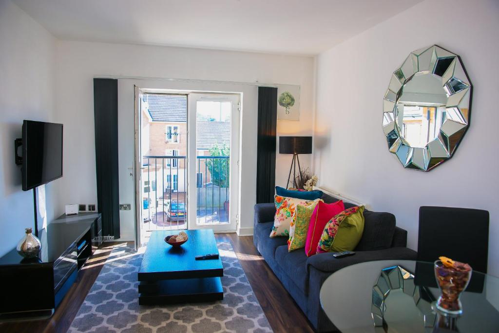 un soggiorno con divano blu e specchio di MODERN 2 BEDROOM APARTMENT a Londra