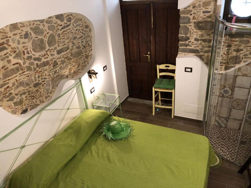 una camera con un letto con un lenzuolo verde di Al castello San Piero Patti a San Piero Patti