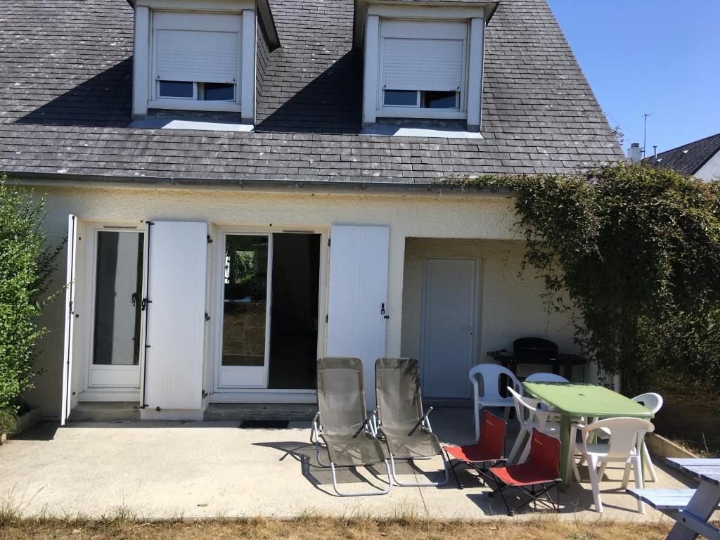 um grupo de cadeiras e uma mesa em frente a uma casa em maison 400 m de la plage em Barneville-Carteret