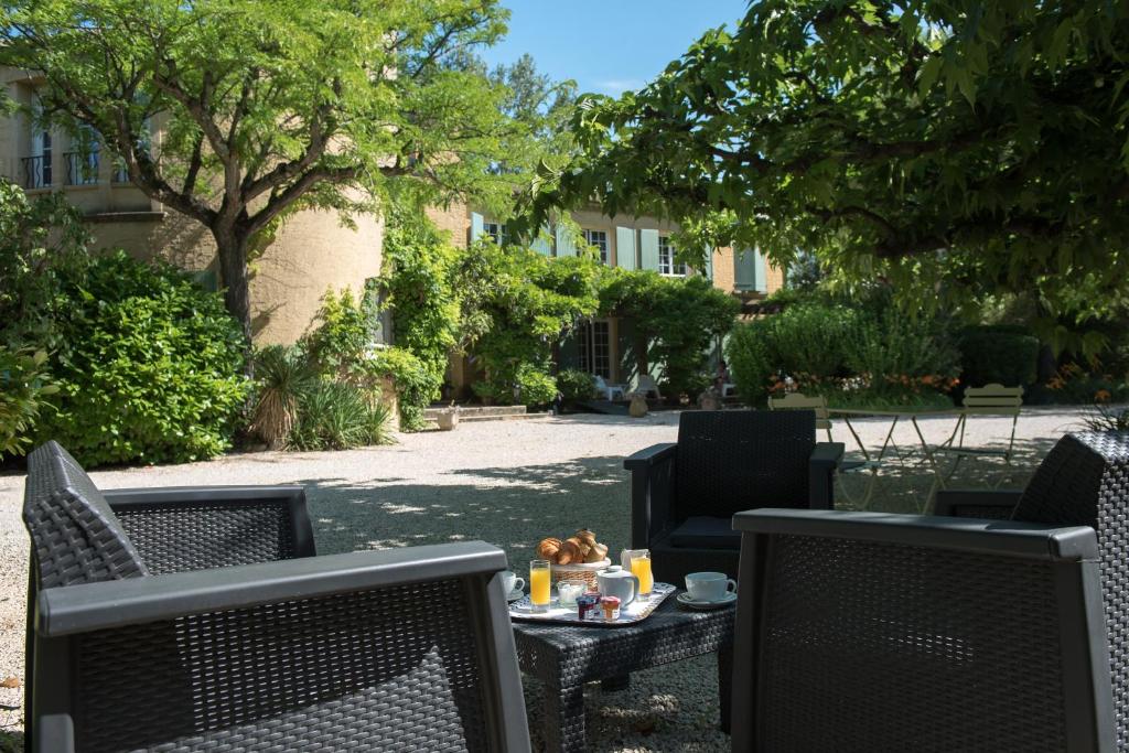 バルバンターヌにあるLogis Hôtel Castel Mouissonのパティオ(椅子2脚、テーブル、食べ物付)