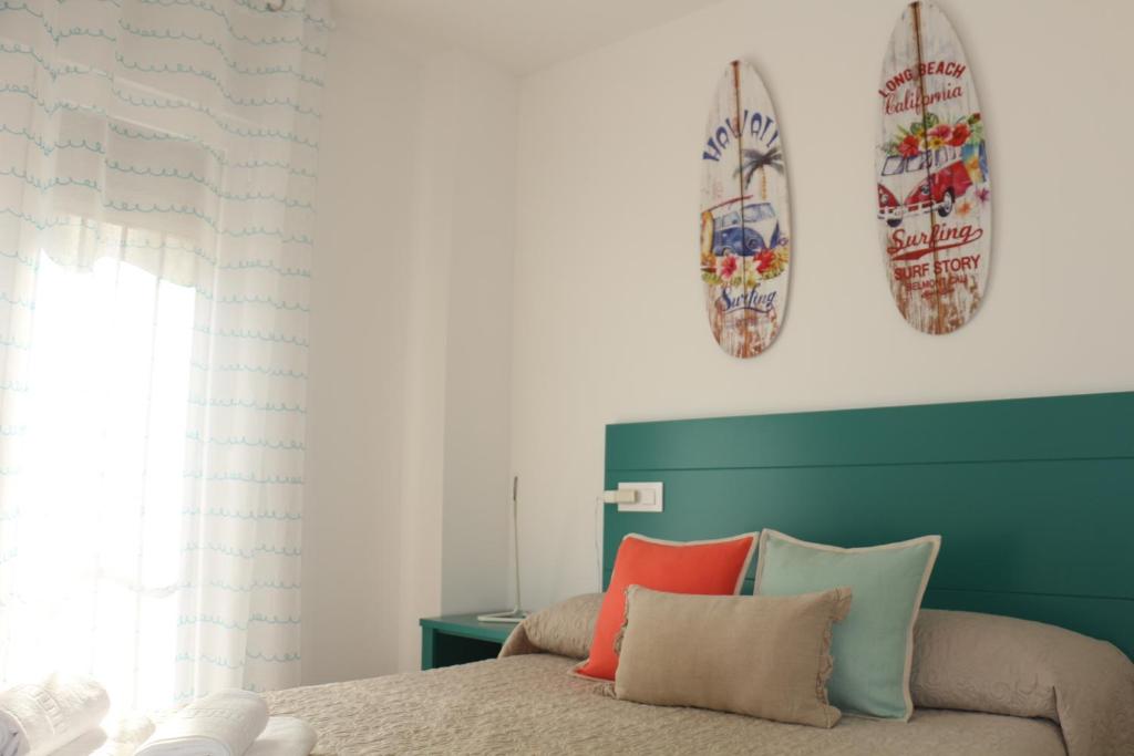 a bedroom with a bed with two surfboards on the wall at Apartamentos Homelife Roca Tarpeya in Toledo