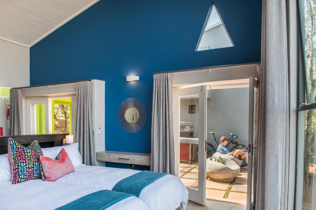 a bedroom with a bed and a blue wall at Bluemere Living in White River