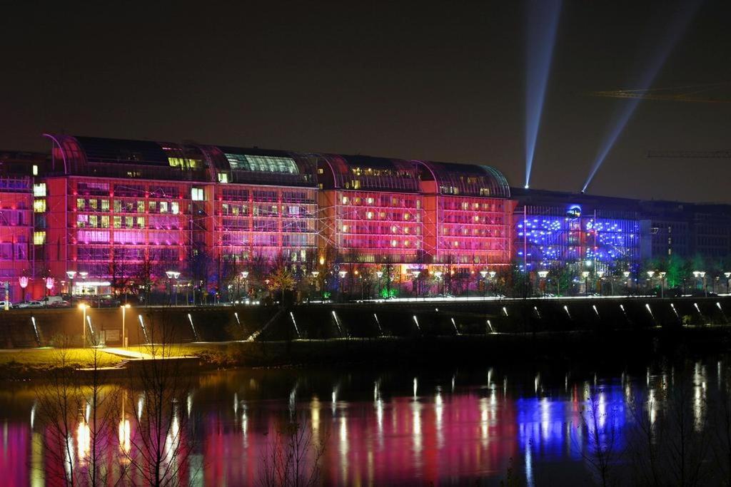 um edifício iluminado com luzes rosa e azul em Appt T3, 55m2 proche Parc Tête D'or et quais du Rhône em Caluire-et-Cuire