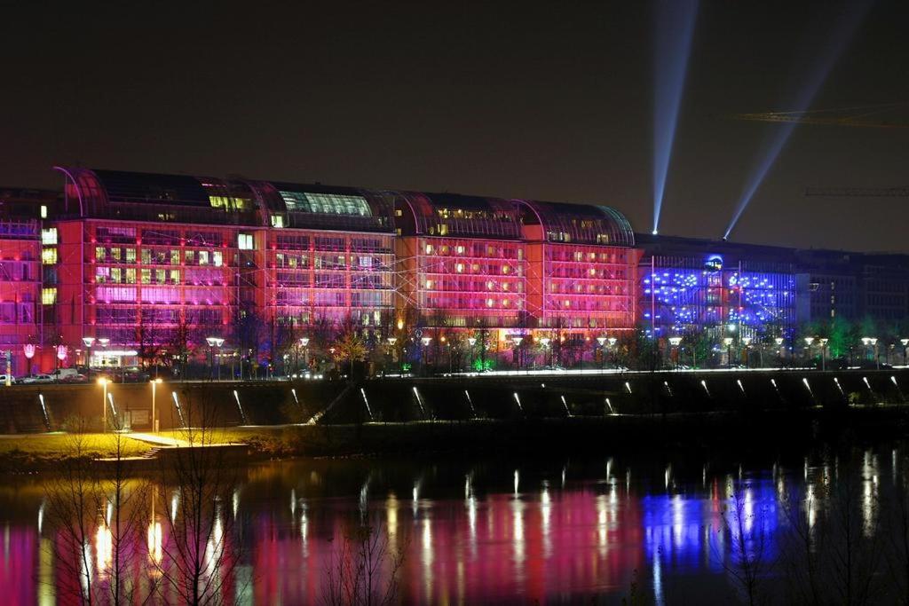un bâtiment éclairé par des lumières roses et bleues dans l'établissement Appt T3, 55m2 proche Parc Tête D'or et quais du Rhône, à Caluire-et-Cuire
