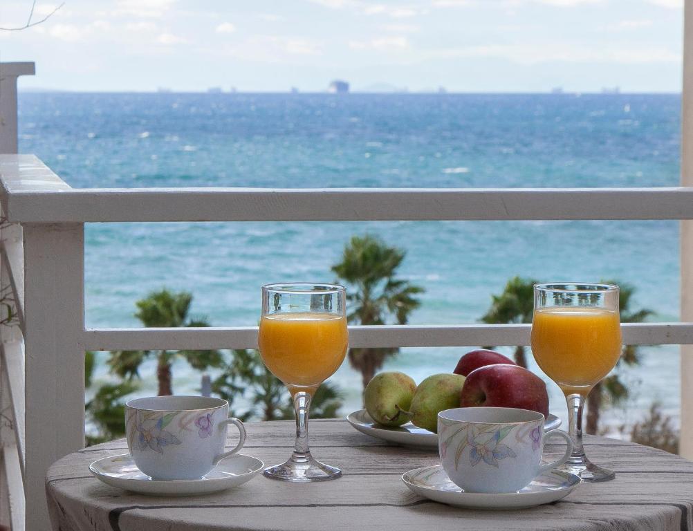 una mesa con dos copas de zumo de naranja y fruta en Edem BeachFront SeaView Dream Home In Beautiful Athens Riviera in Palaio Faliro, en Atenas