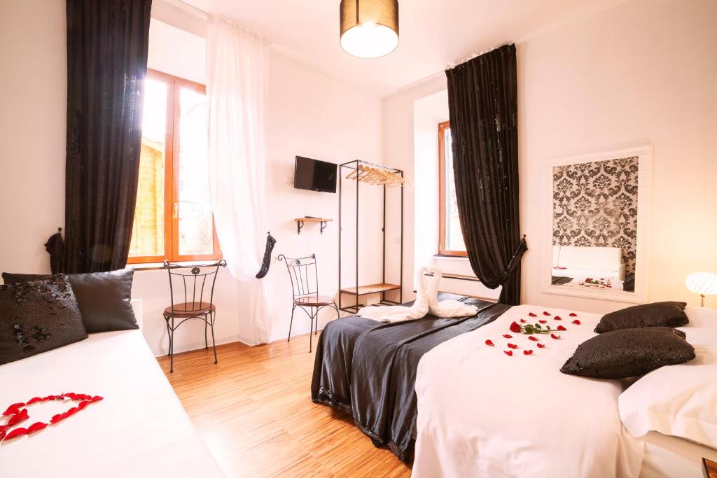 um quarto com 2 camas, uma mesa e cadeiras em Ostiense Suites em Roma