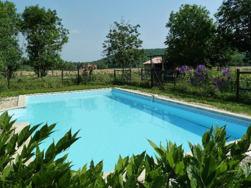 duży błękitny basen na dziedzińcu w obiekcie La Pénardière w mieście Saint-Étienne-de-Tulmont