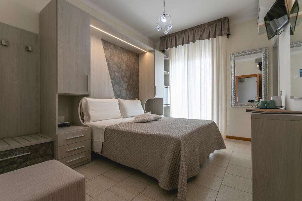 una camera d'albergo con letto e specchio di Hotel Deborah a Milano Marittima