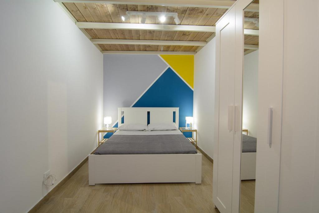 a bedroom with a bed and a colorful wall at Ficodì apartments in Alcamo