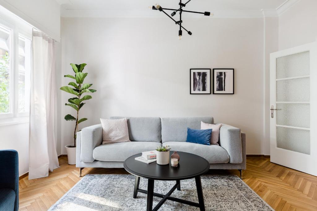 a living room with a couch and a table at Acropolis Heart 2BD Apartment in Plaka by UPSTREET in Athens