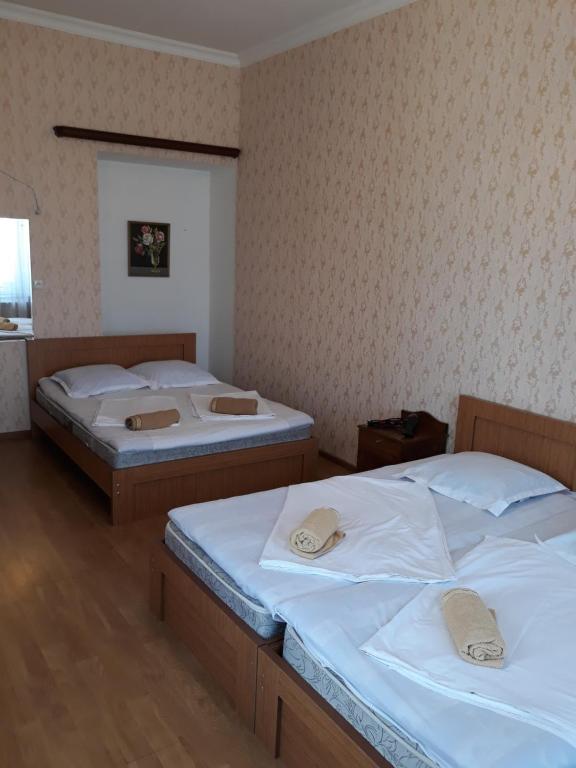 two twin beds in a room with a wall at Guesthouse Gia in Tbilisi City