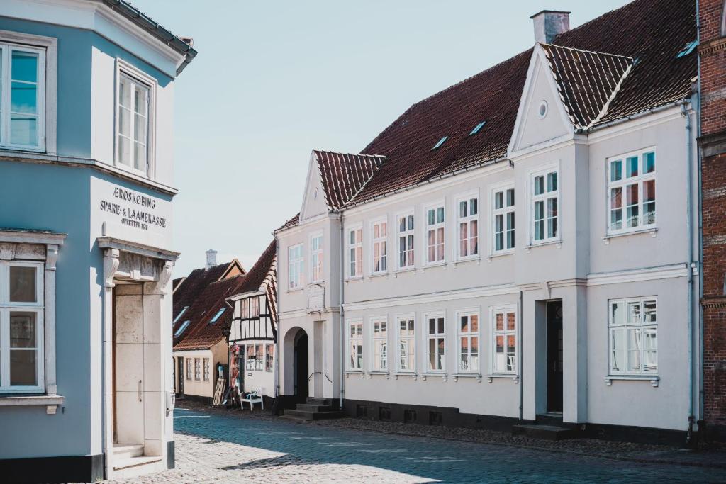 una fila de edificios blancos en una calle en Kjobing Manor, en Ærøskøbing