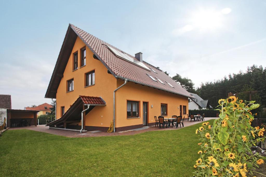 una grande casa gialla con uno scivolo nel cortile di Am Waldrand Spreewald a Burg