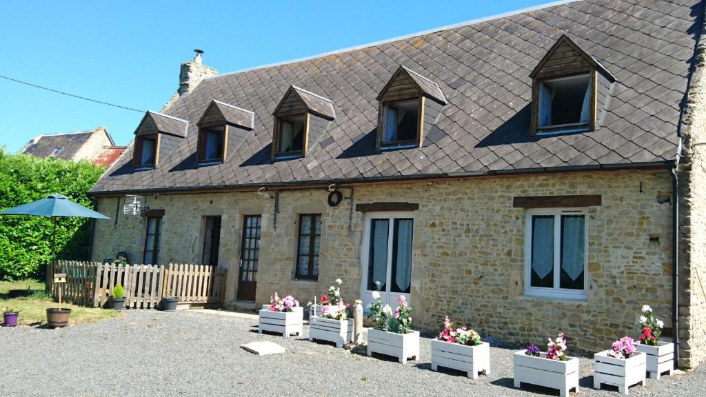 a brick house with potted plants in front of it at Gîte chez Lili in Aignerville