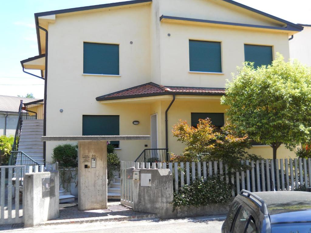 una casa bianca con una recinzione di fronte di "Villa Bruna" a Legnago