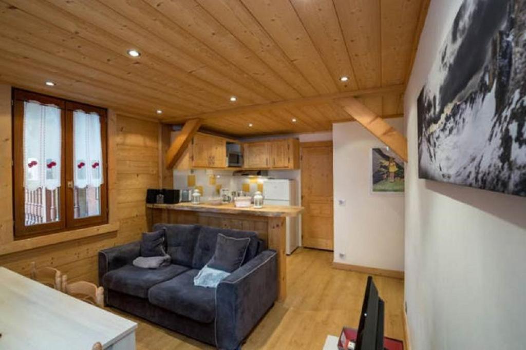 a living room with a couch and a kitchen at Résidence Mont Joly2 in Saint-Gervais-les-Bains