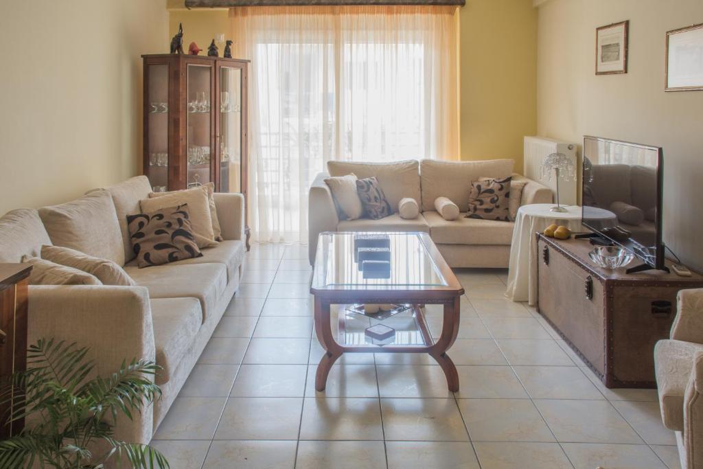 uma sala de estar com um sofá e uma mesa de centro em Artemis central apartment em Kórinthos