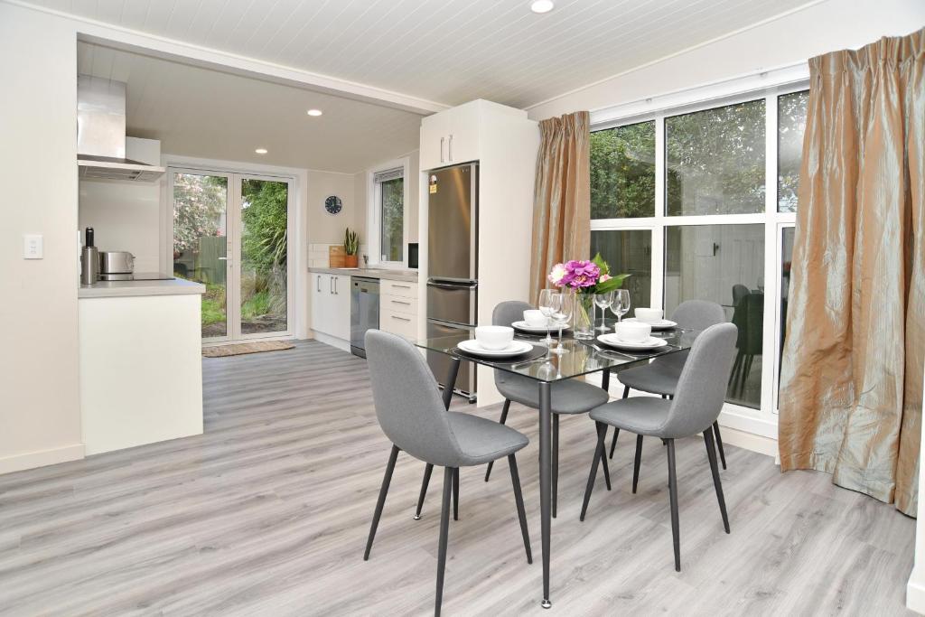 a kitchen and dining room with a table and chairs at Albemarle Villa - Christchurch Holiday Homes in Christchurch