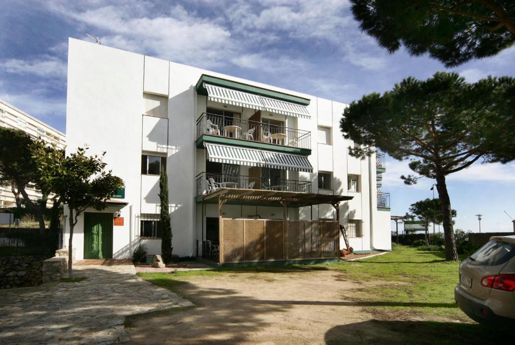 un edificio blanco con balcones en un lateral en Apartaments Les Roques, en Platja d'Aro