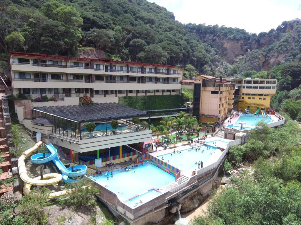 a hotel with a large pool and a water slide at Hotel y Aguas Termales de Chignahuapan in Chignahuapan