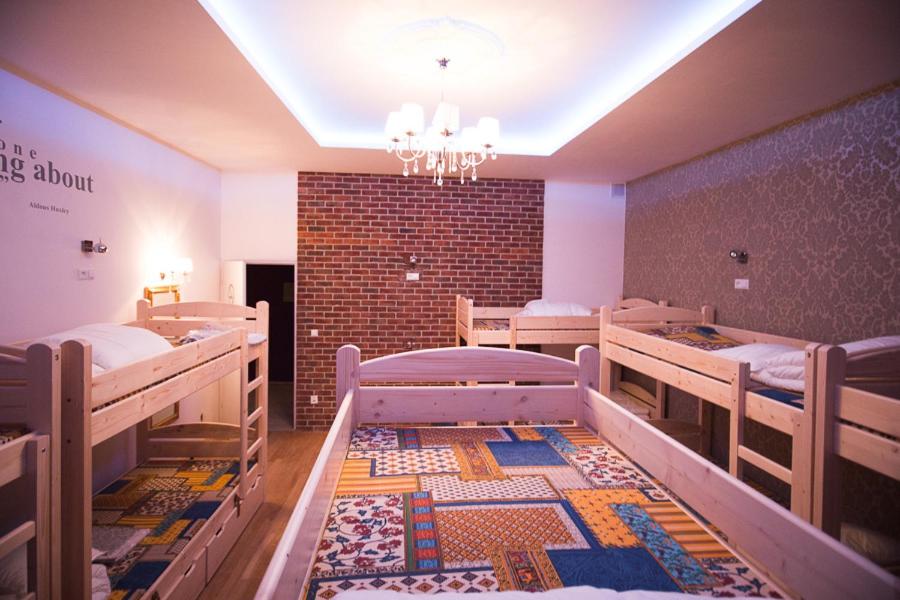 a room with three bunk beds and a brick wall at Greg&Tom Beer House Hostel in Krakow